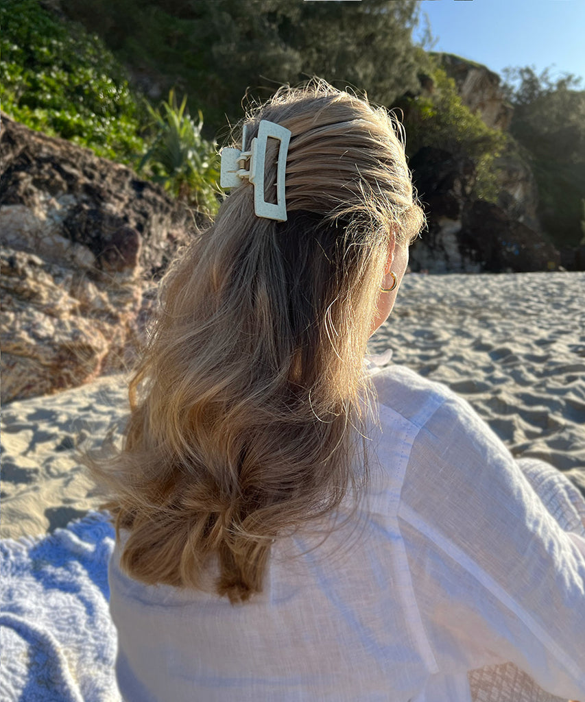 Model on the beach wearing sustainable Lexi green hair claw clip