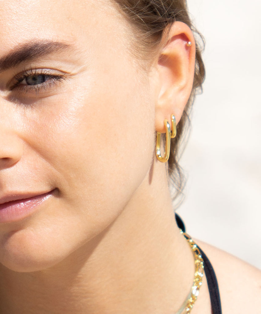 Model at Byron Bay beach wearing Avoca mini gold vermeil earrings