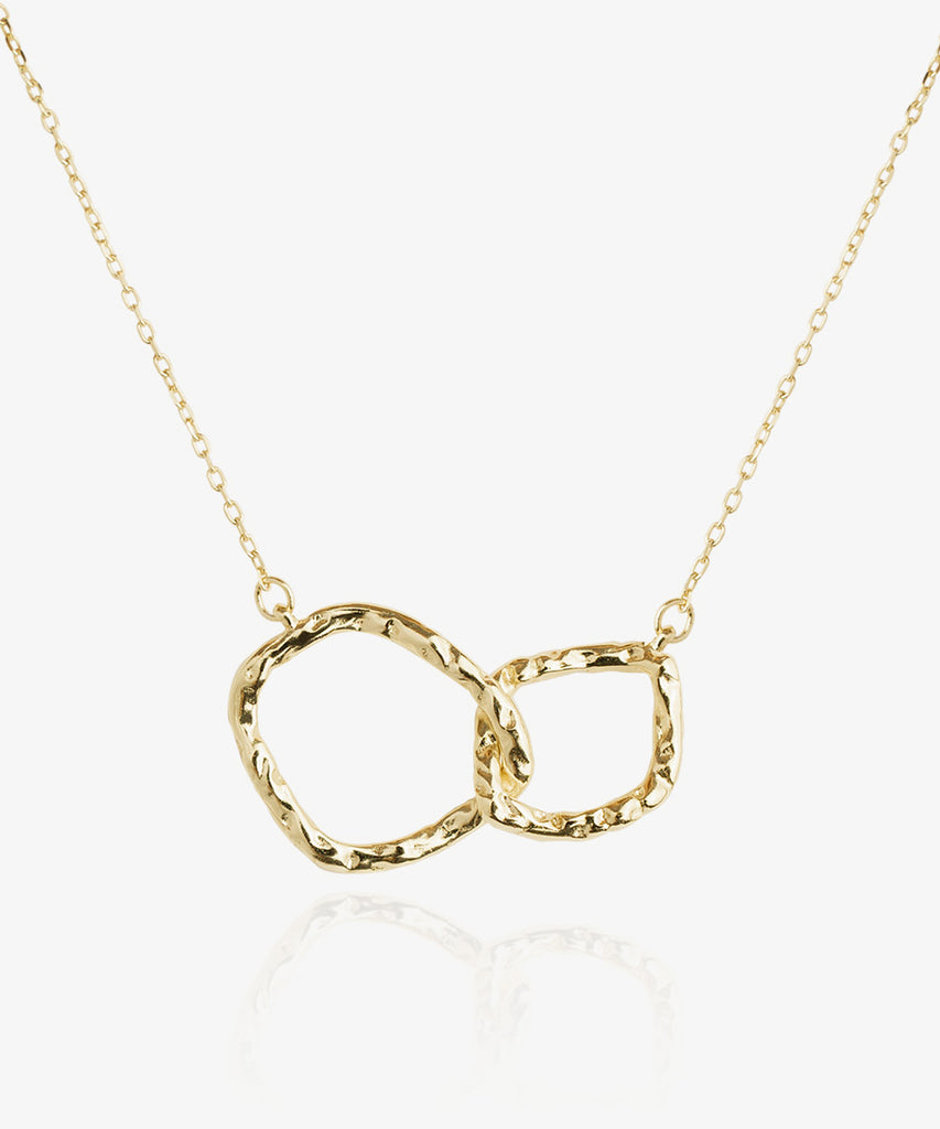 Beautiful gold plated Harmony necklace which has two natural design circular shapes interlocking on white background