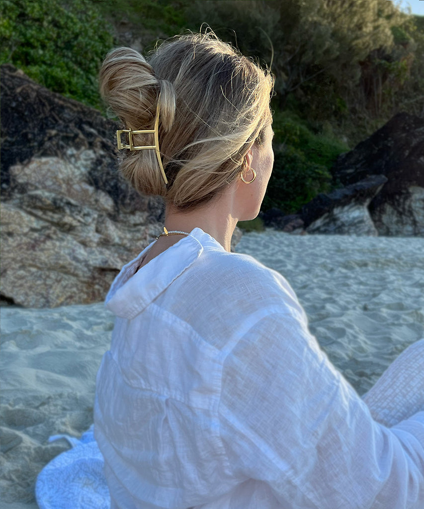 Model on the beach wearing gold Layla hair claw clip