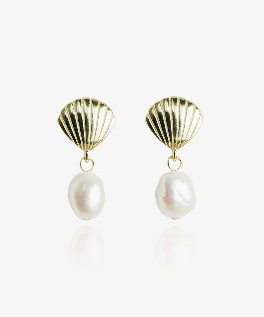 Gold shell earrings with pearls on white background